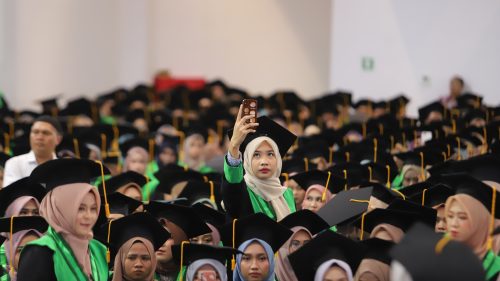 Seorang wisudawati sedang mengabadikan momen temannya diwisuda (Foto-Humas-Yulida Rifani)