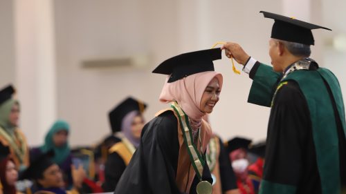 Wisudawati Fakultas Dakwah dan Ilmu Komunikasi Fitriatul Awaliyyah saat dipindahkan tali topi toganya oleh Dekan Dr. H. M. Abduh Amrie, M.A. (Foto-Humas-Yulida Rifani)