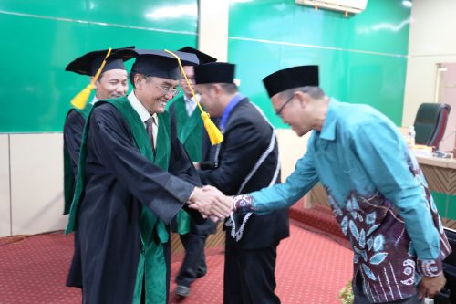 Rektor IAIN Palangkaraya Dr. H. Khairil Anwar, M.Ag. saat mengucapkan selamat kepada kerabat M. Sauqi (Foto-Humas-Hadi Rustami)