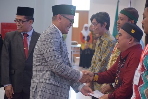 Karo AUPKK UIN Antasari Dr. H. Adnan Nota, M.A. saat menyerahkan bentuk bantuan kepada Maswan, pegawai pramubakti di Bagian Administrai dan Umum (Foto-Humas-Hadi R