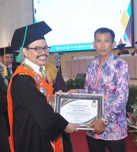 Rektor menyerahkan penghargaan kepada ASN senior berdedikasi tinggi yang juga fotografer andal Humas UIN Antasari (Foto-Humas)