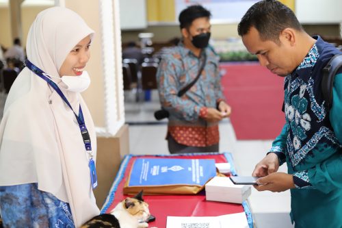 Pegawai Mikwa UIN Antasari Mardhiatinnisa, S.Sos. bersama kucing dengan ramah melayani registrasi para peserta (Foto:Humas/Hadi Rustami)