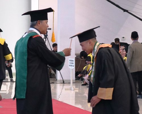 Dekan Fakultas Dakwah dan Ilmu Komunikasi UIN Antasari Dr. H. M. Abduh Amrie, M.A. saat memindah tali topi toga Hafizul Akhtar (Foto:Humas/Achmad Magfur)