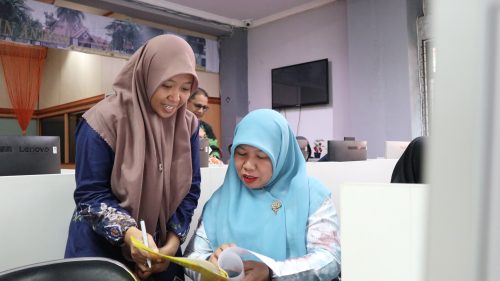 Staf Administrasi LPM UIN Antasari Maulida Rezkia, S.Pd. (yang berdiri) saat membantu kelancaran acara (Foto:Humas/Achmad Magfur)