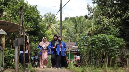 Para mahasiswi UIN Antasari saat menaiki jalan setapak di Desa Haruyan Dayak Kecamatan Hantakan Kabupaten HST (Foto:Humas/Achmad Maghfur)