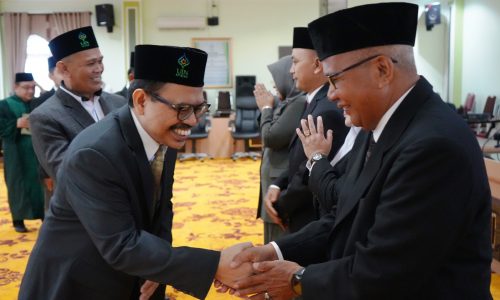 Rektor UIN Antasari (kanan) saat memberikan ucapan selamat kepada Drs. M. Idris, M.Pd.I. (Foto:Humas/Hadi Rustami)