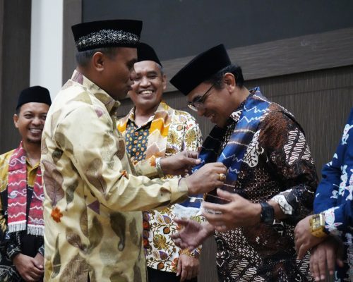 Perwakilan Wali Kota Banjarmasin saat mengalungkan kenang-kenangan kain sasirangan kepada para tamu (Foto:Humas/Hadi Rustami)