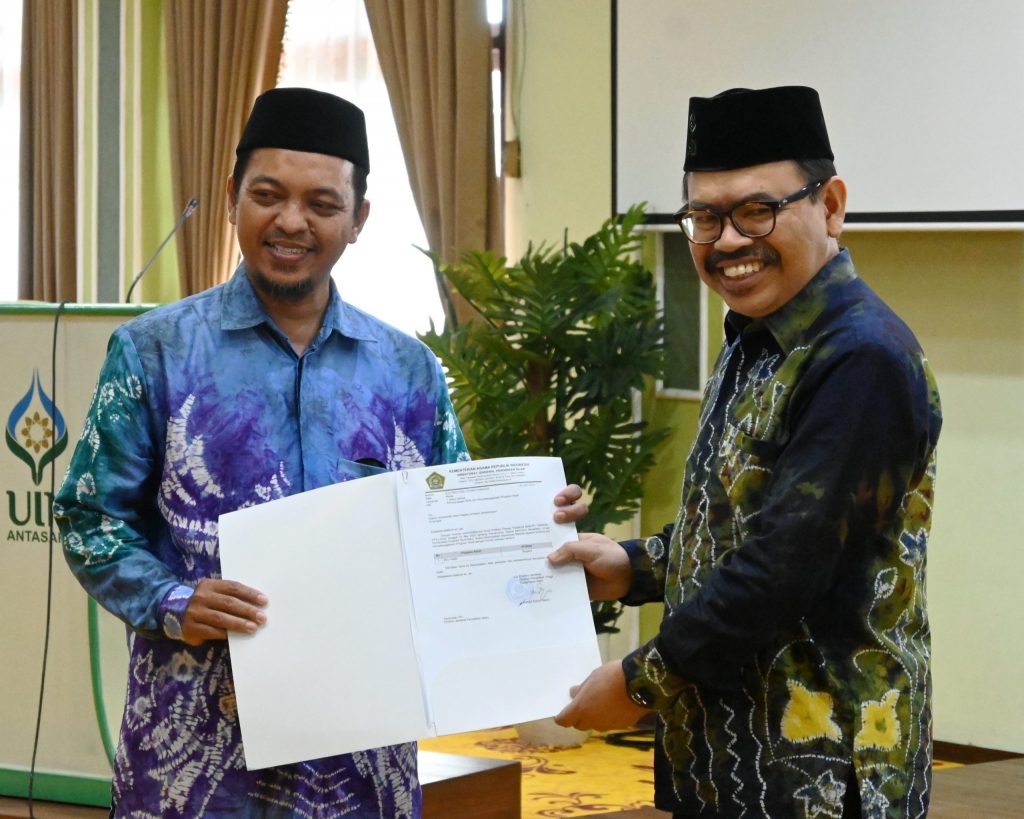 Dekan FUH Dr. Dzikri Nirwana, M.Ag. (kiri) saat menerima SK Prodi Ilmu Hadis dari Rektor UIN Antasari Prof. Dr. H. Mujiburrahman, M.A. (Foto:PPL/M. Hifzi Addini)