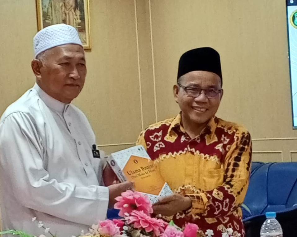Dr. Nuryadin, M.Ag. saat menyerahkan hadiah Buku Ulama Banjar dari masa ke masa karya Tim UIN Antasari