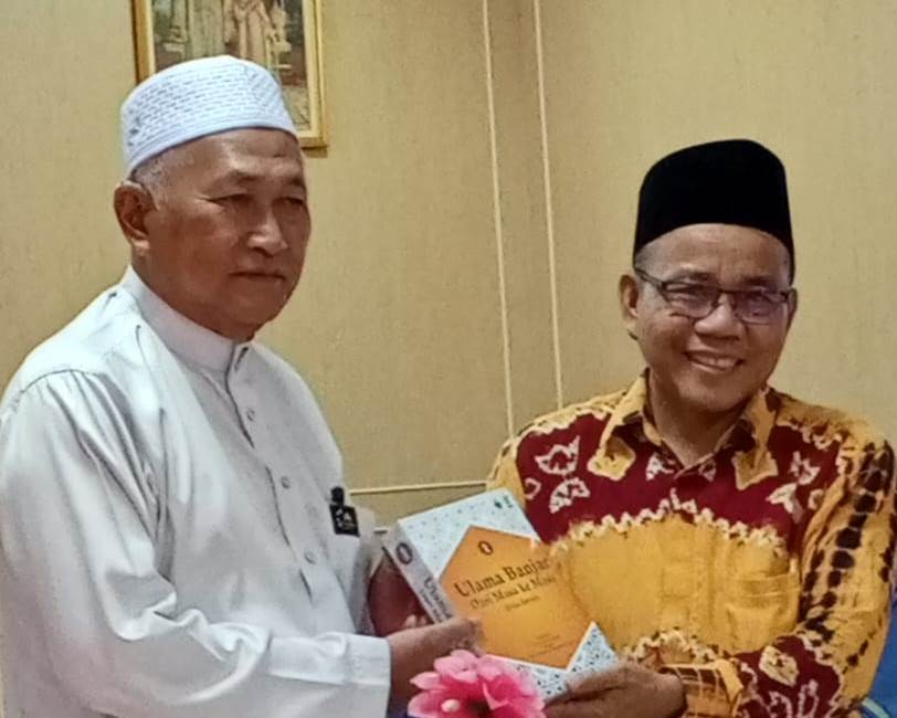 Koordinator Pusat Pengabdian kepada Masyarakat Dr. Nuryadin, M.Ag. saat menyerahkan kenang-kenangan berupa Buku Karya Dosen UIN Antasari