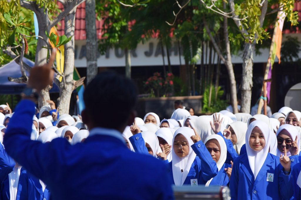 Tetap senyum dan semangat para mahasiswi baru saat berpanas-panas mendengarkan orasi Ketua Panitia Pelaksana PBAK 2023 Ahmad Riyadi Purnawan (Foto:Humas/Achmad Magfur)