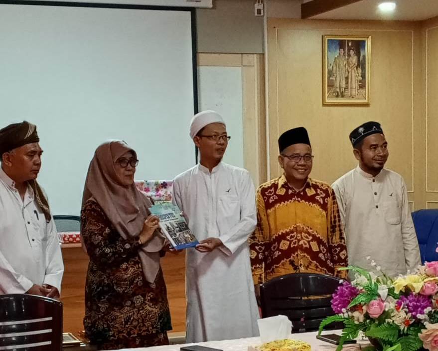 Wakil Rektor Bidang Akademik dan Kelembagaan Dr. Hj. Nida Mufidah, M.Pd. saat menyerahkan buku profil UIN Antasari