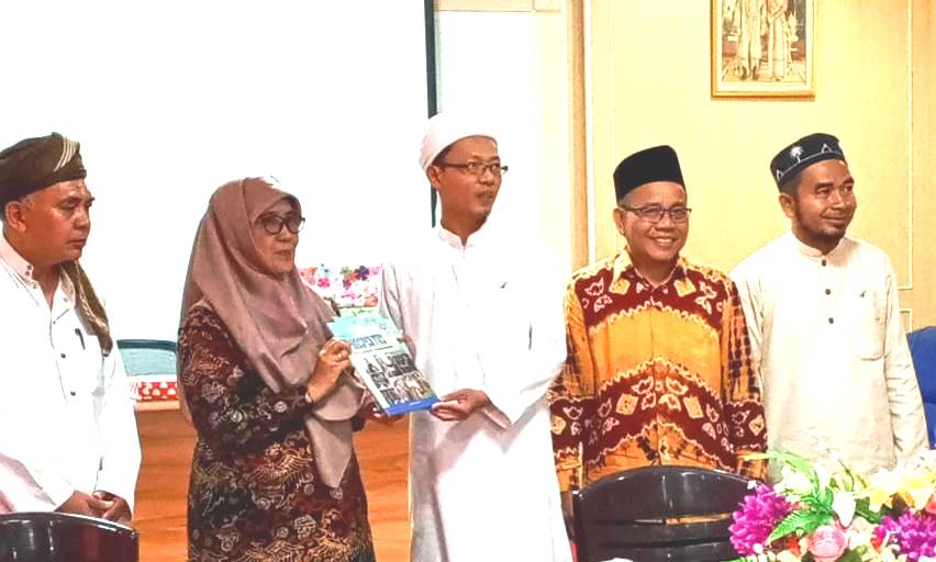 Wakil Rektor Bidang Akademik dan Kelembagaan Dr. Hj. Nida Mufidah, M.Pd. saat menyerahkan kenang-kenangan berupa buku profil UIN Antasari