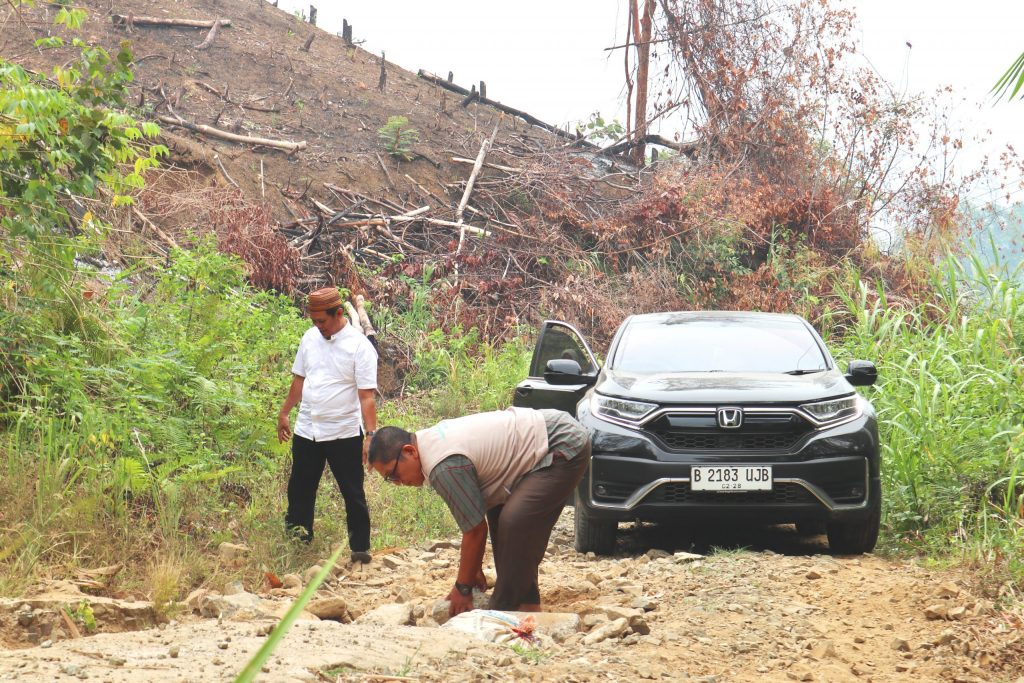 H. Ibnu Arabi, M.Fil.I. saat merapikan bebatuan agar bisa melewati tanjakan (Foto:Humas/Achmad Magfur)