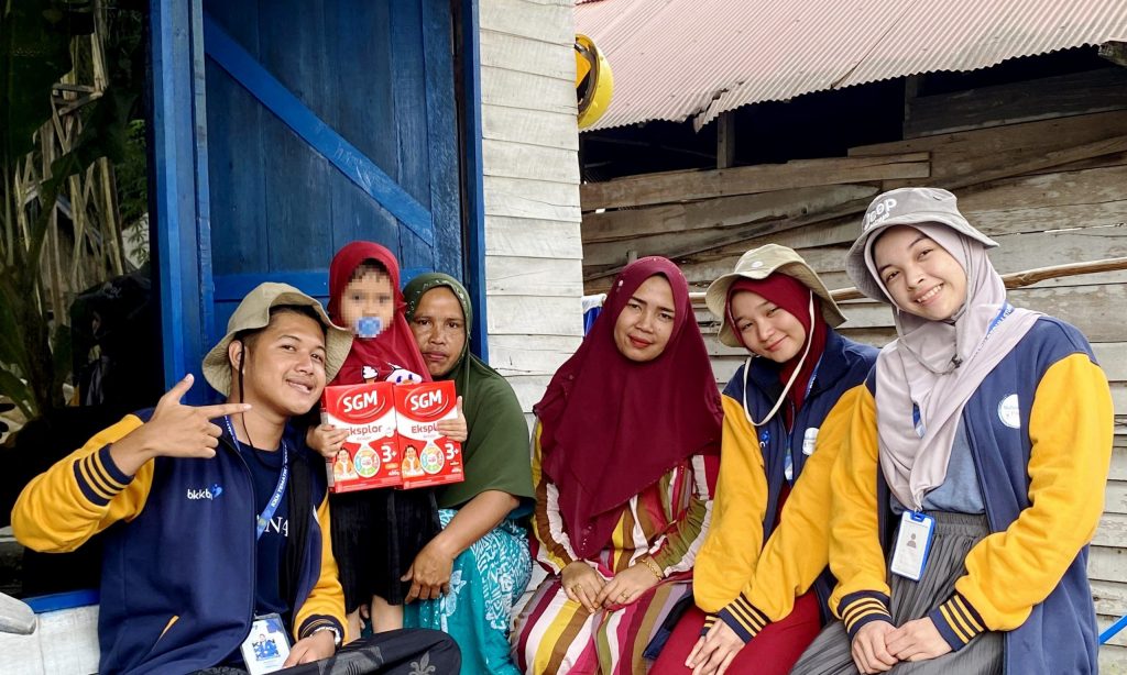 Mahasiswa KKN UIN Antasari saat membantu penyaluran rutin pemberian minuman tambahan kepada 9 anak rawan tengkes di Marampiau Hilir.