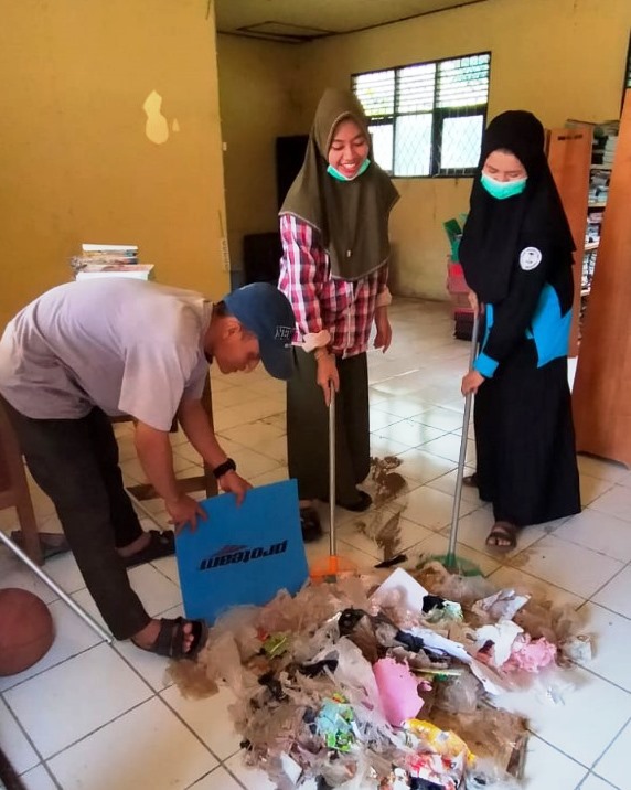 Para mahasiswa KKN UIN Antasari saat membantu membersihkan SDN 2 Haruyan Dayak.