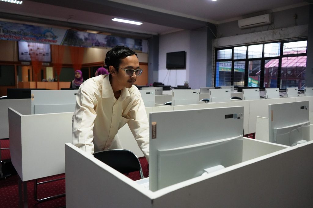 Aulia Akbar Setyogomo, S.Kom. saat mempersiapkan komputer untuk kelancaran SKTT (Foto:Humas/Achmad Magfur)