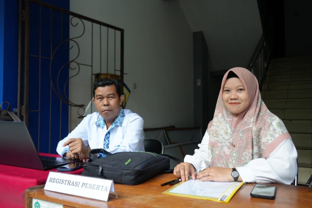 Nasrullah, S.A.P. dan Nadya, S.Pd. saat bersiap-siap menyambut para peserta di meja registrasi (Foto:Humas/Achmad Magfur)