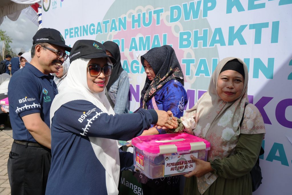 Ketua DWP UIN Antasari Hj. Mariani Mujiburrahman, S.Ag., S.Pd.I. saat didampingi Rektor menyerahkan bantuan sosial (Foto:Humas/Hadi Rustami)