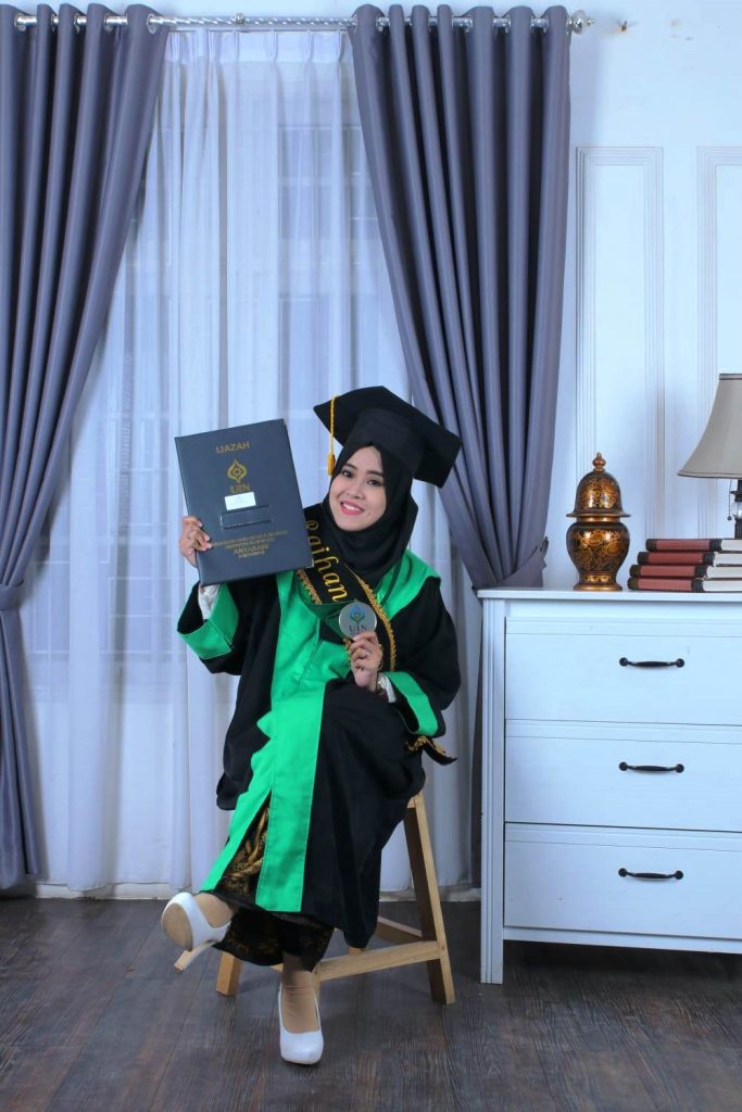 Raihanah, S.Pd. ceria berfoto usai wisuda tahun 2019 lalu.