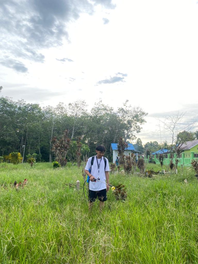 Mahasiswa KKN UIN Antasari saat membantu pembersihan pemakaman umum Desa Tebing Tinggi.