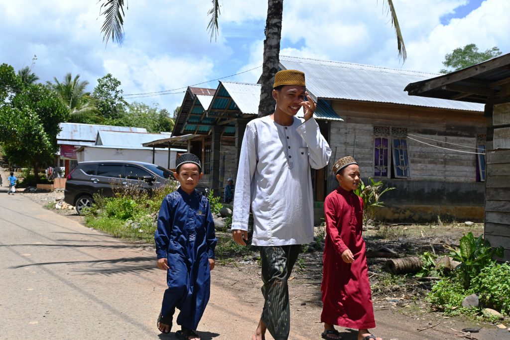 Muhammad Faizal, mahasiwa KKN Desa Nateh saat mengajak anak-anak ke masjid berjamaah (Foto:Humas/Achmad Magfur)