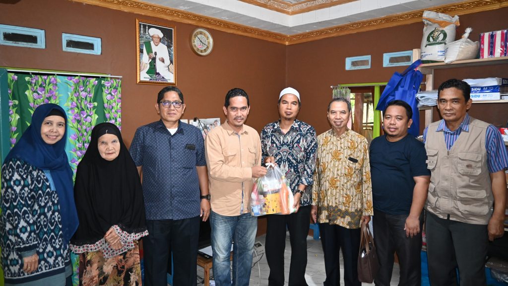 Tokoh Agama Paramasan Bawah Guru Syahwani, S.H. saat menerima bantuan dari UIN Antasari (Foto:Humas/Achmad Magfur)