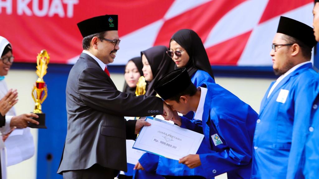 Rektor UIN Antasari Prof. Dr. H. Mujiburrahman, M.A. saat menyerahkan penghargaan kepada Akhmad Arifin, Juara 1 KTIF KINMU I, (Foto Yulida Rifani)