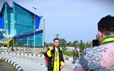 Akhmad Maulana Hafiz, S.E. saat berfoto berlatar Gedung Rektorat Kampus 2 (Foto Humas Jamal Ripani)