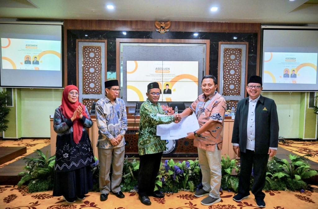 Kaprodi S-1 MPI FTK UIN Antasari Drs. H. Muhammad Yuseran, M.Pd. saat menyerahkan berita acara (Foto:Humas)