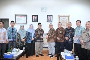 Rektor saat menyerahkan kenang-kenangan berupa Al-Qur'an terjemah Bahasa Banjar kepada Ketua Muda Kamar Agama MA RI (Foto:Humas/Jamal Ripani)