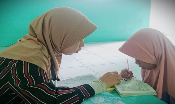 Anak-anak Desa Masiraan saat didampingi mahasiswa untuk belajar mengaji.