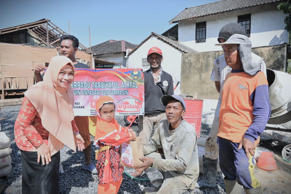 Ketua DWP UIN Antasari saat mendampingi pembagian bantuan dari anak-anak PAUD Terpadu Tarbiyatul Athfal (Foto:Humas)