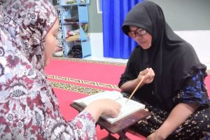 Mahasiswi KKN MBKM UIN Antasari saat melakukan pendampingan pembelajaran membaca Al-Qur'an.
