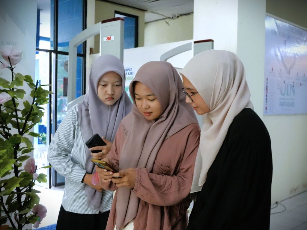 Para mahasiswi saat melihat koleksi digital Perpustakaan UIN Antasari (Foto:Humas/Rahmi Hartati)