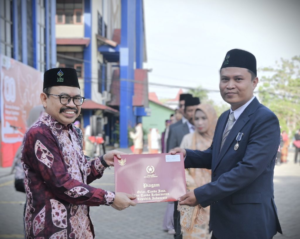 Rektor saat menyerahkan piagam kepada Dr. Moch. Isra Hajiri, S.IPI., M.Hum. (Foto:Humas/Jamal Ripani)