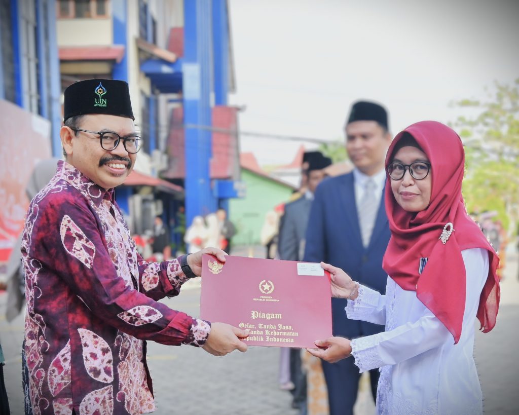 Rektor saat menyerahkan piagam kepada Yusrina Hidayati, S.Ag., M.M. (Foto:Humas/Jamal Ripani)