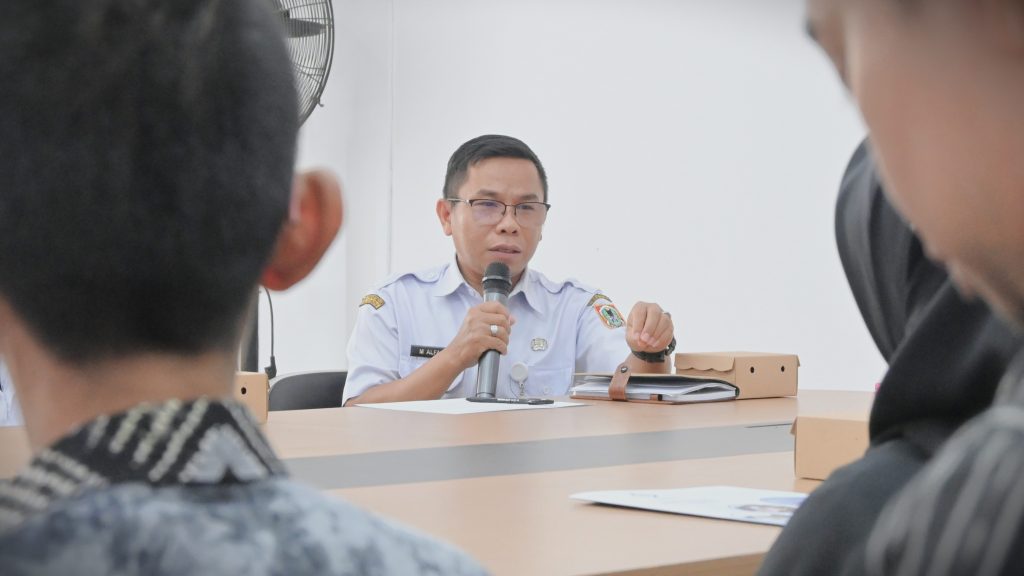 Arsiparis Pelaksana Dispersip Kalsel Muhammad Al Fajri saat menjelaskan layanan yang ada (Foto:Humas/Jamal Ripani)