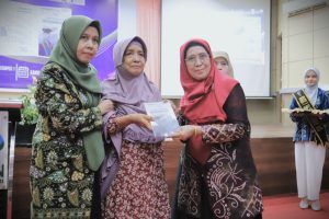Prof. Dr. Hj. Masyithah Umar, M.Hum. saat menyerahkan buku kenang-kenangannya kepada pimpinan UIN Antasari (Foto:Humas/Haitami)