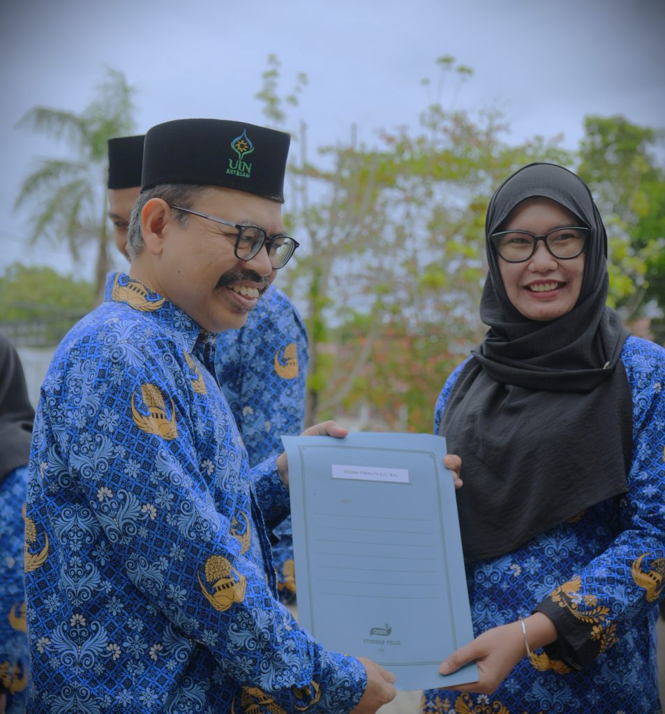 Rektor saat menyerahkan SK kenaikan pangkat kepada Ergina Faralitas, M.H. (Foto:Humas/Rudy Hermawan)