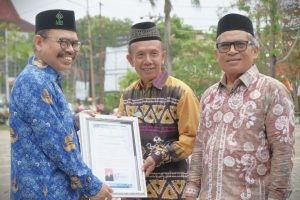 Rektor saat menyerahkan penghargaan purnatugas kepada Fahruddin, B.A., S.A.B., M.E. (Foto:Humas/Rudy Hermawan)