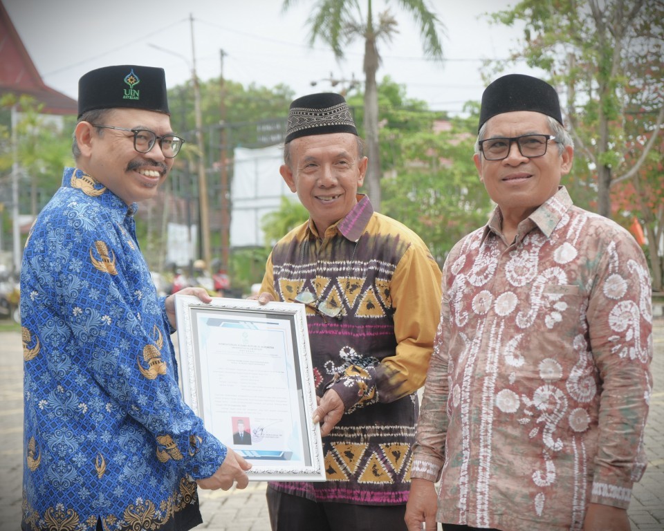 Rektor saat menyerahkan penghargaan purnatugas kepada Fahruddin, B.A., S.A.B., M.E. (Foto:Humas/Rudy Hermawan)