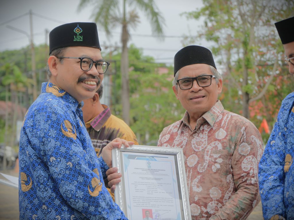 Rektor saat menyerahkan penghargaan purnatugas kepada H. Arbani, S.Sos., M.A. (Foto:Humas/Rudy Hermawan)