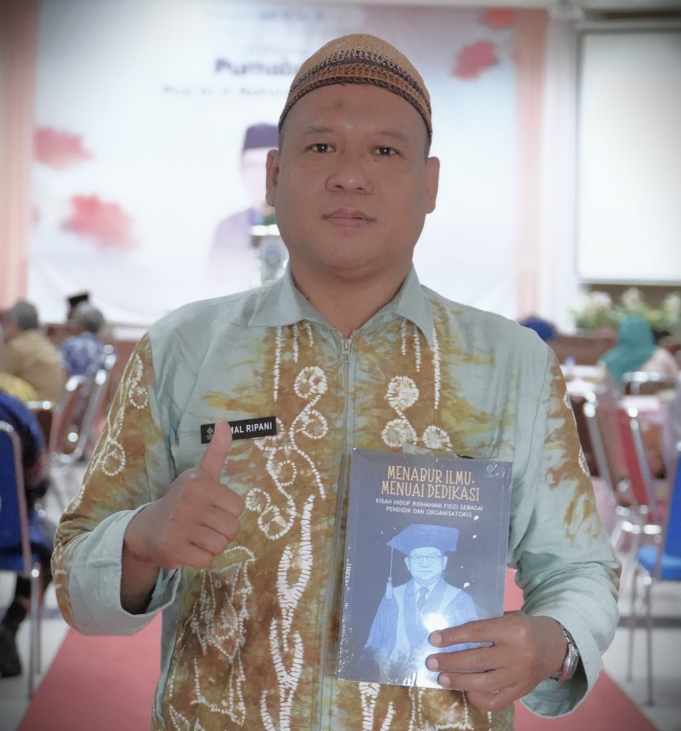 Jamal Ripani, M.Pd. saat menerima buku biografi Prof. Dr. H. Ridhahani Fidzi, M.Pd. berjudul Menabur Ilmu, Menunai Dedikasi (Foto:Humas/Haitami)