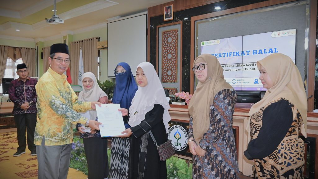 Prof. Dr. H. Akhmad Sagir, M.Ag. saat menyerahkan Sertifikat Halal kepada Hj. Rohani (Foto:Humas/Jamal Ripani)