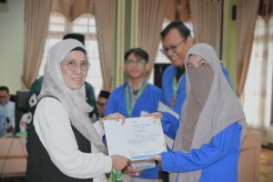 Wakil Rektor saat menyerahkan penghargaan kepada Siti Nurul Hikmah (Foto:Humas/Jamal Ripani)