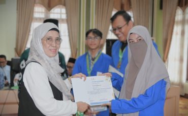 Wakil Rektor saat menyerahkan penghargaan kepada Siti Nurul Hikmah (Foto:Humas/Jamal Ripani)