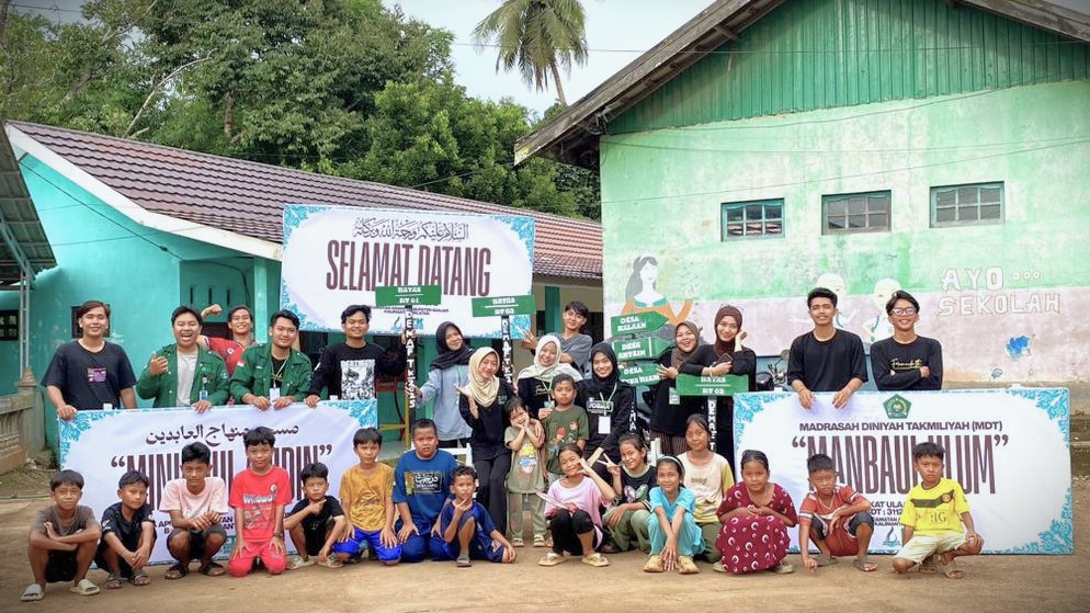 Foto bersama usai membuatkan plang desa dan madrasah.