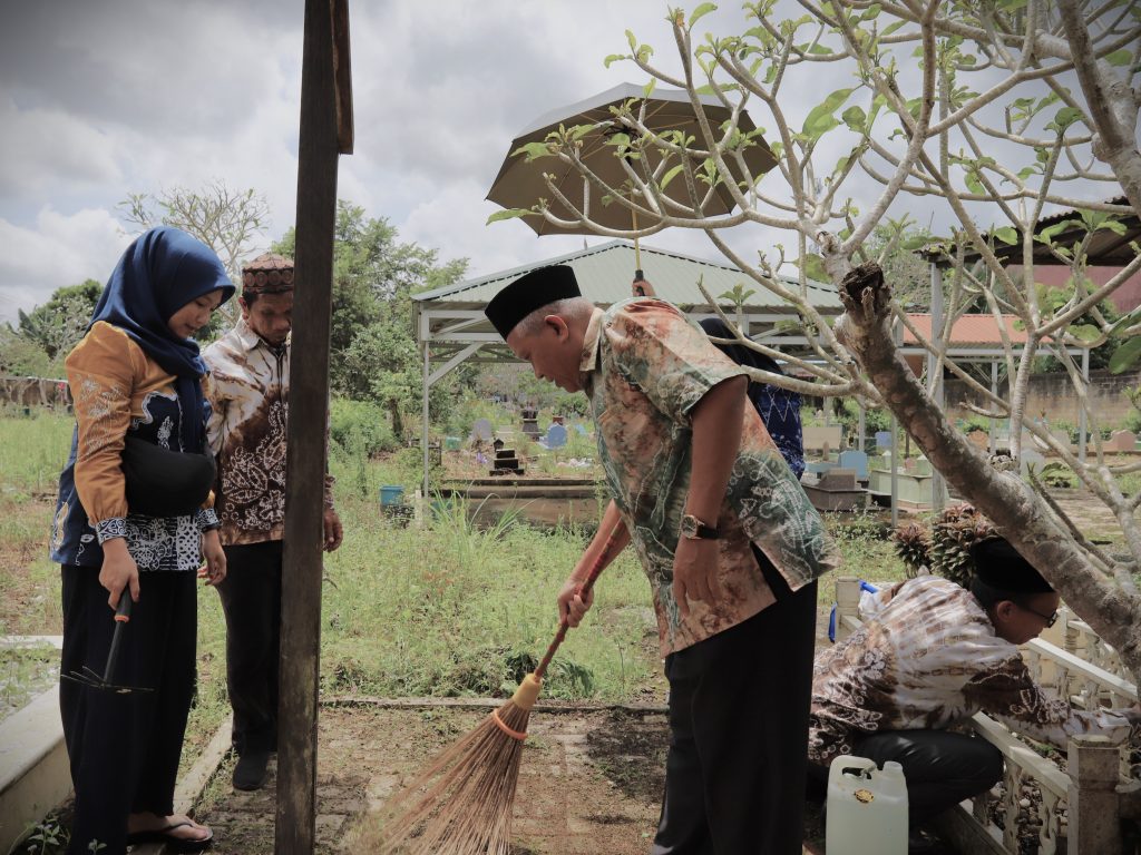 Kabag Umum UIN Antasari Masri, S.Ag., M.Pd. saat membersihkan makam (Foto:Humas/Haitami)