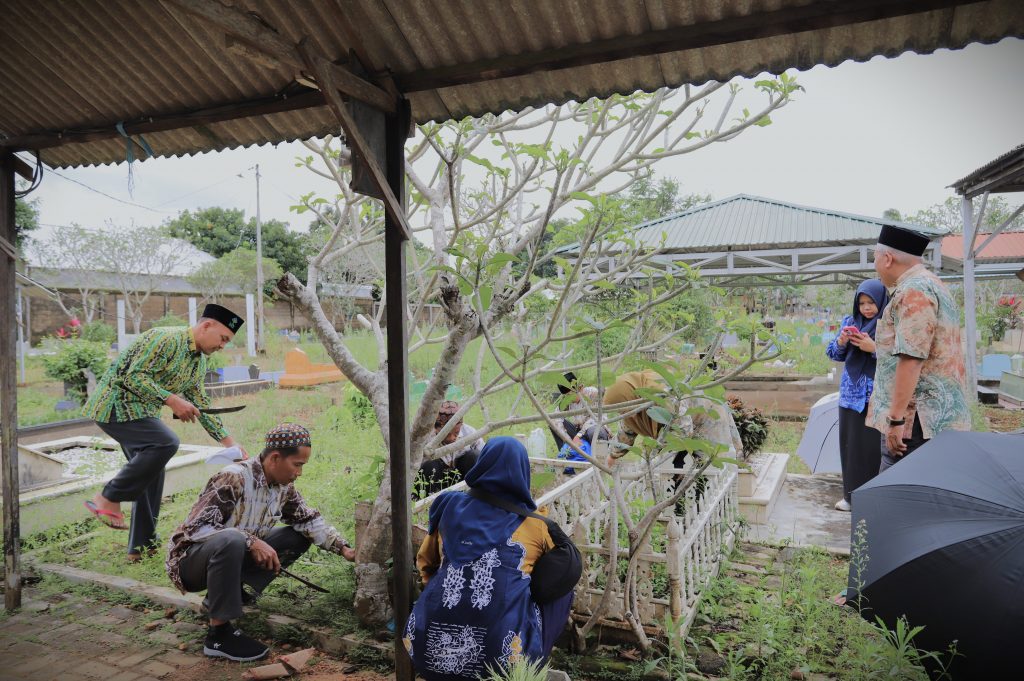 Panitia saat bergotong royong membersihkan makam (Foto:Humas/Haitami)